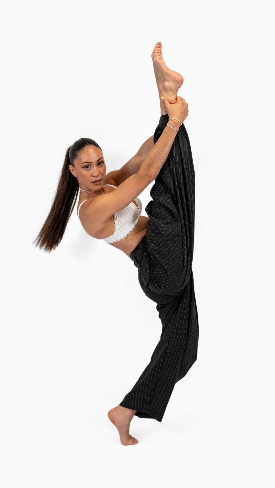 Danseuse en extension verticale, jambe tenue contre l'épaule